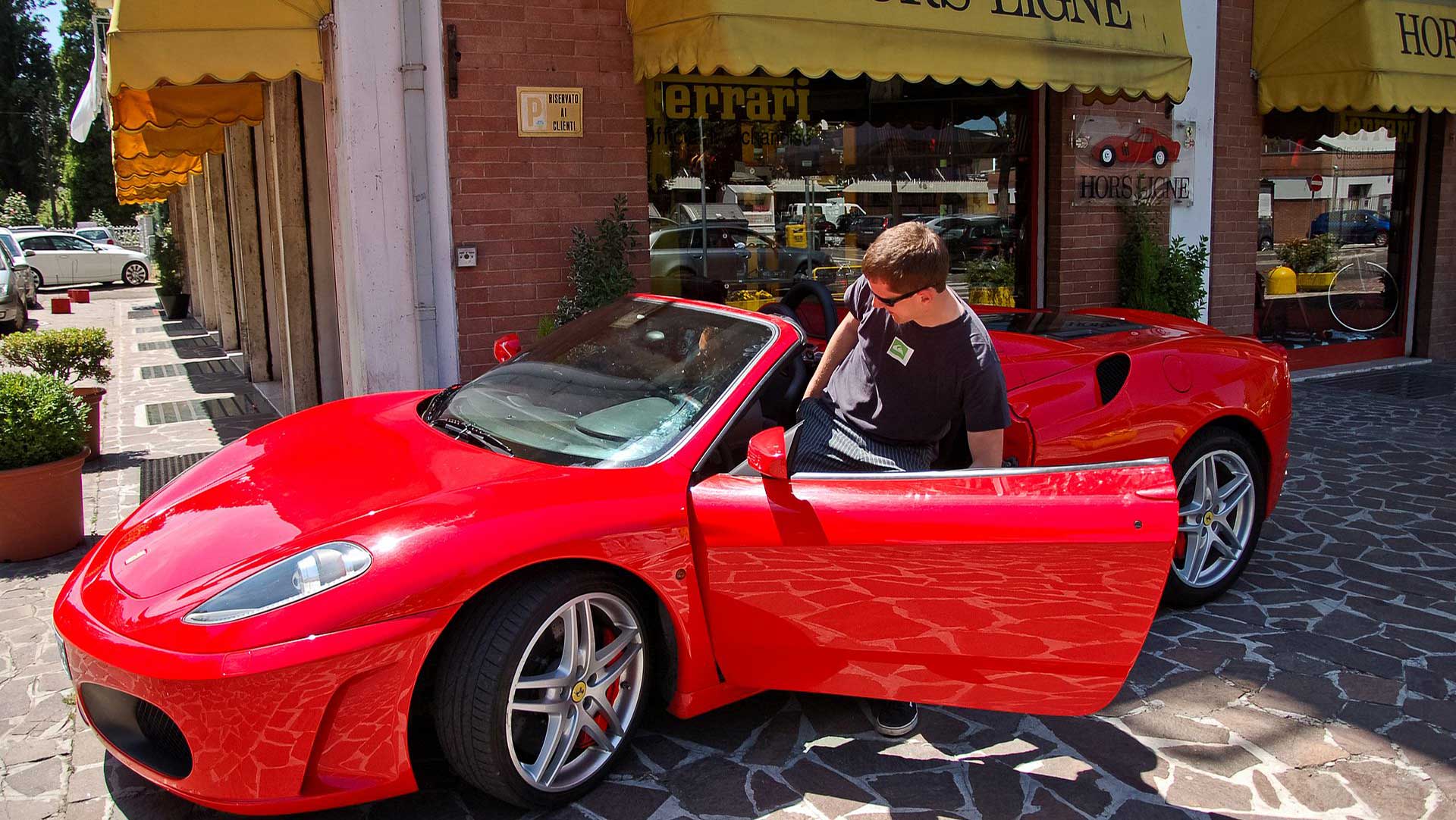 Young man sits into Ferrari F430
